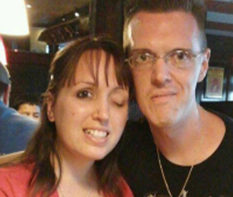 A man and woman posing for a picture in a restaurant.