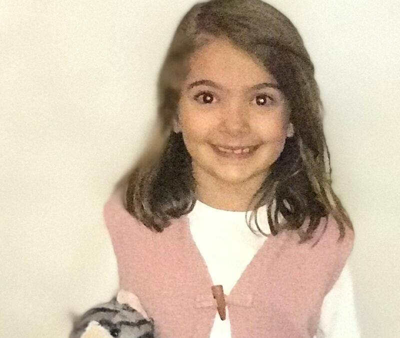 A young girl holding a stuffed animal.