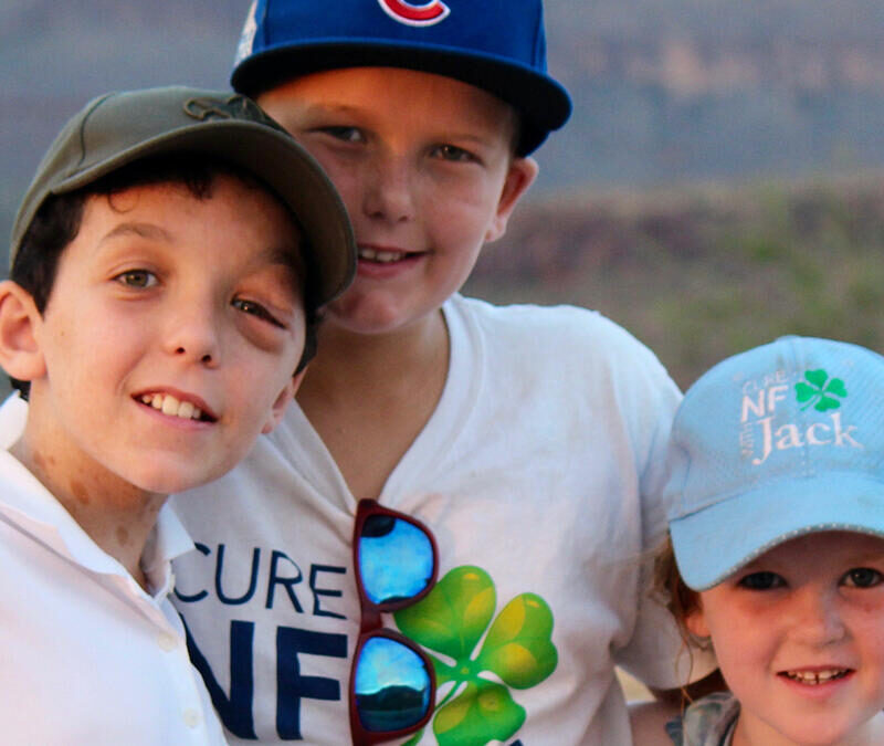 Three boys in hats posing for a picture.