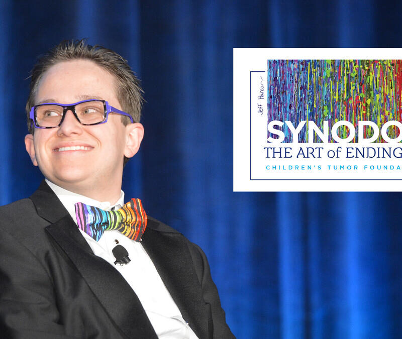 A man in a suit and bow tie is smiling.