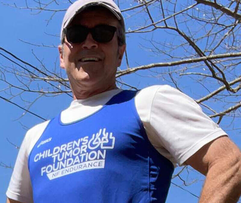 A man in a blue t - shirt is posing for a photo.