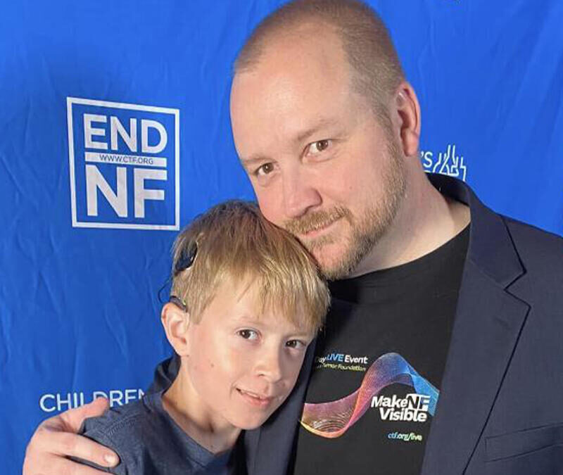 A man is hugging a young boy at an end nf event.