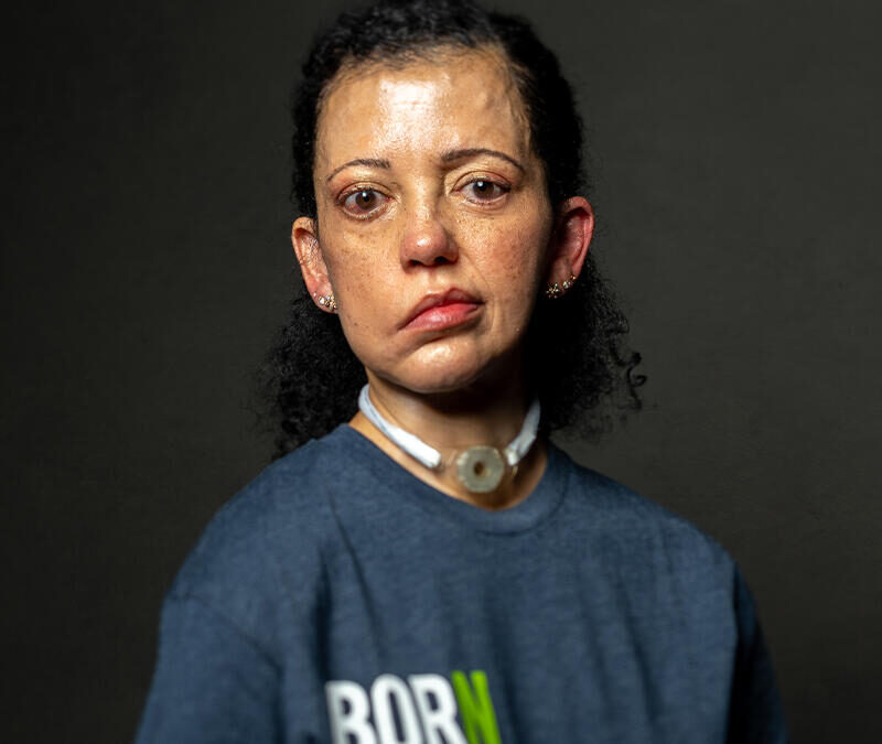 A woman wearing a blue t - shirt.