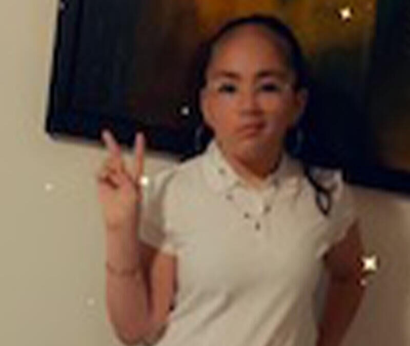 A girl in a white shirt posing for a picture.
