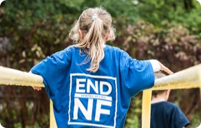A child wearing a blue shirt with the words end nf on it.
