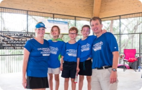 A group of people in blue shirts posing for a picture.