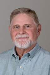 A man with a beard and a blue shirt.