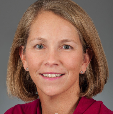 A portrait of a woman wearing a pink shirt.