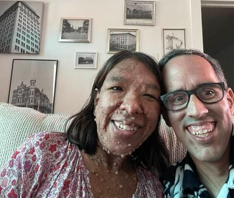 A man and woman taking a selfie in a living room.