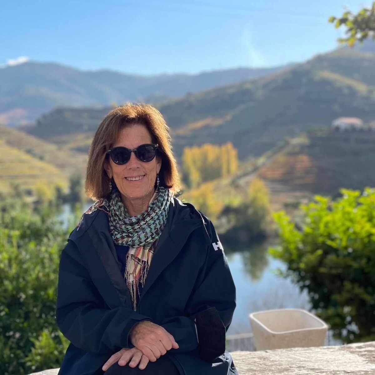 Susan Salpeter sitting in front of picturesque mountains
