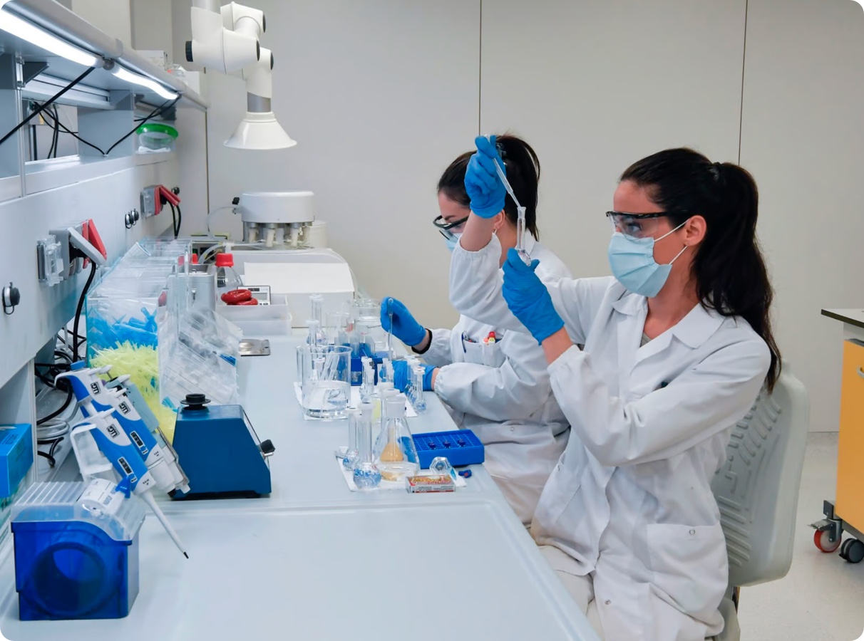 Two women in lab coats working in a lab.