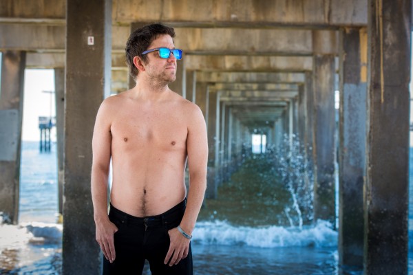 man standing in front of ocean wearing sunglasses