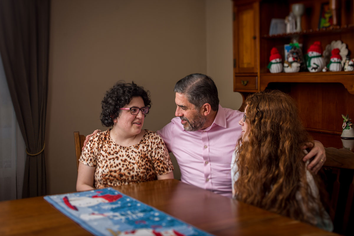 A family sits at a table and looks at each other.