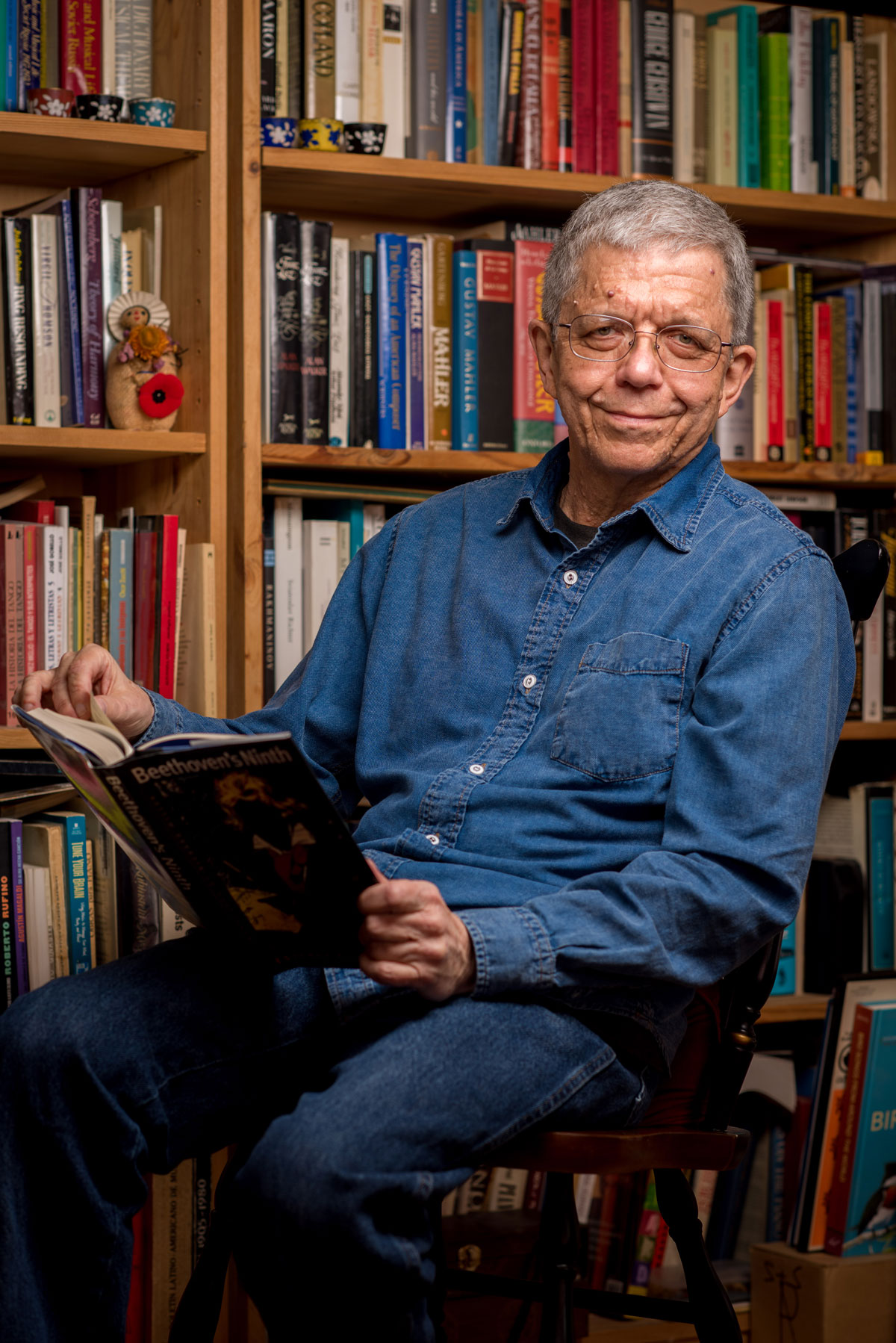 A man sitting in a chair holding a book.