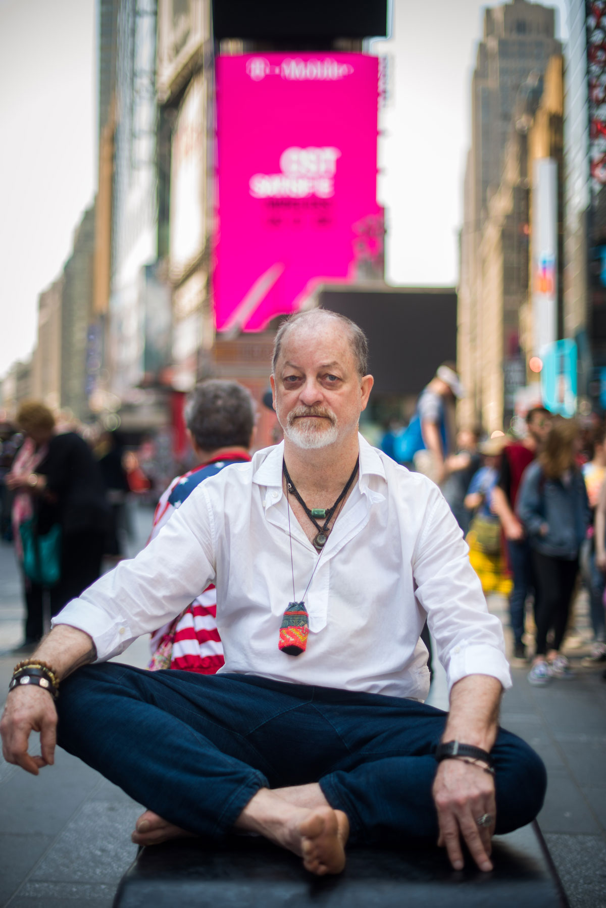 A man sitting on a bench in a city.