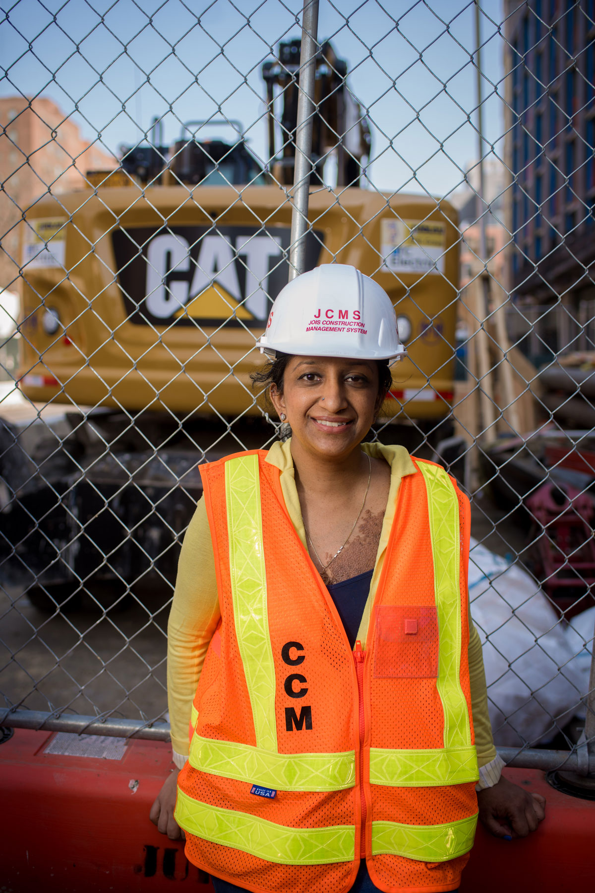 A woman standing in front of a construction site.