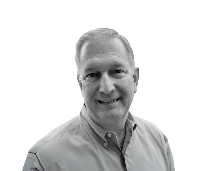 A black and white photo of a man smiling.