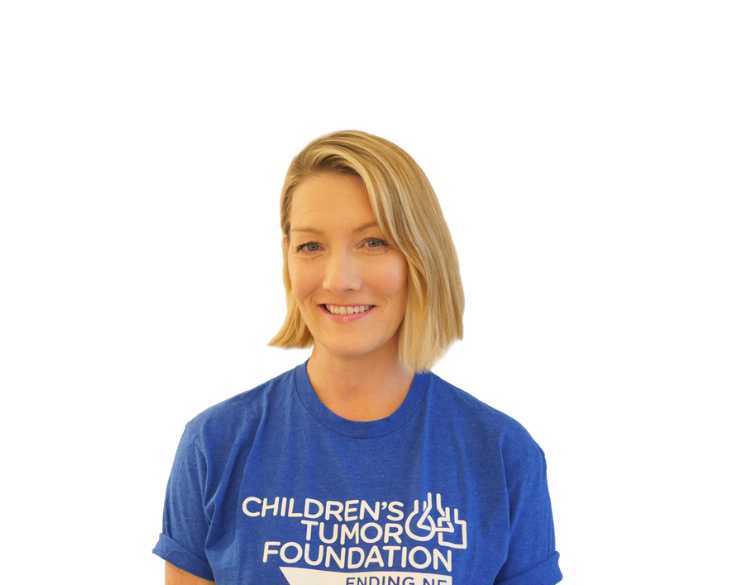 A woman wearing a blue t - shirt that says children's tumor foundation.