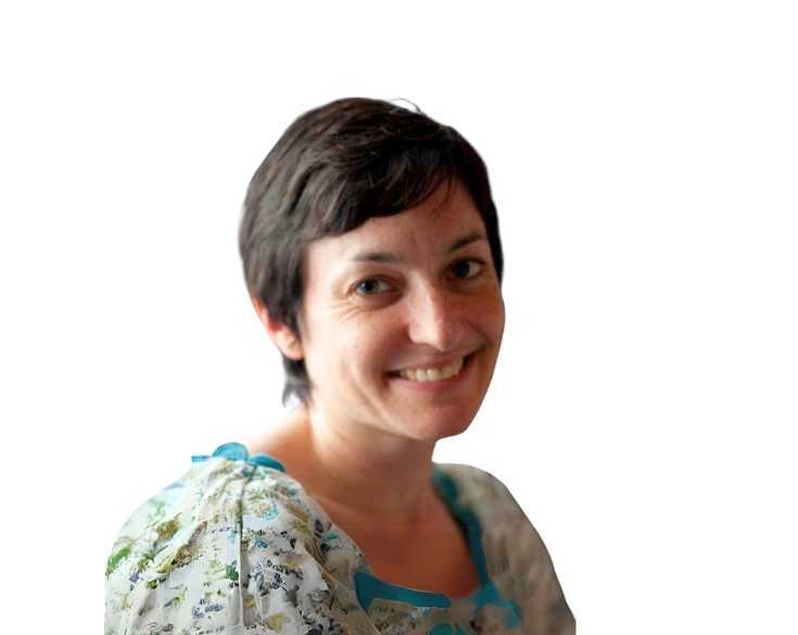 A woman in a floral top smiles for the camera.