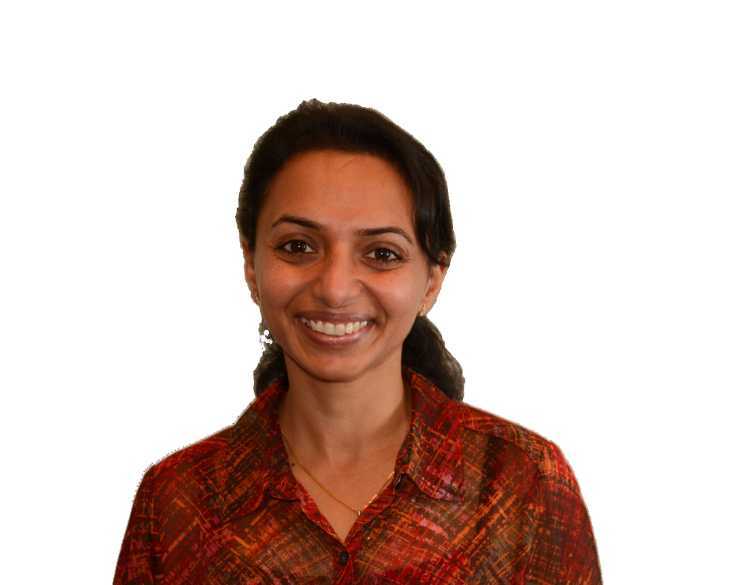 A smiling woman in a plaid shirt.