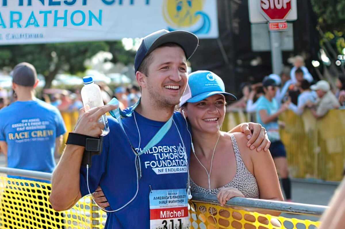 A man and woman posing for a photo at a race.