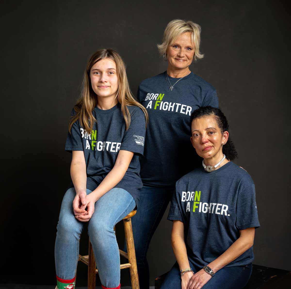 Three women posing for a photo in a t - shirt.