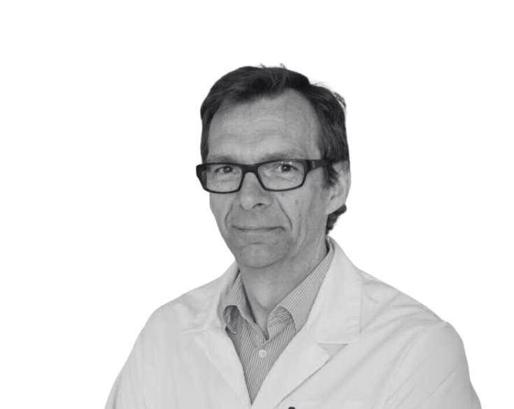 A black and white photo of a man in a lab coat.