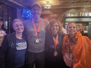 A group of people posing for a photo with medals.