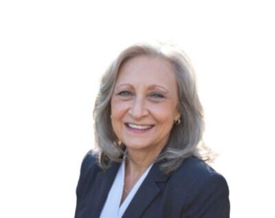 A woman in a business suit smiling for the camera.