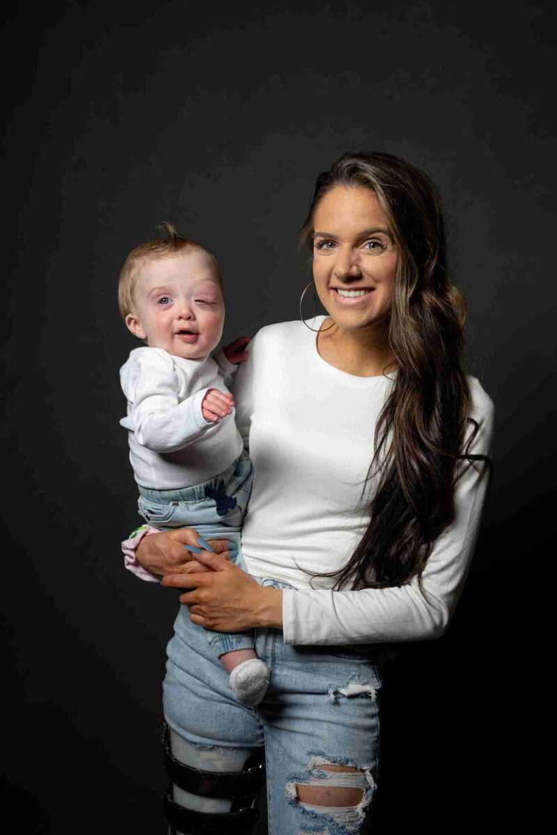 A woman holding a baby on a black background.