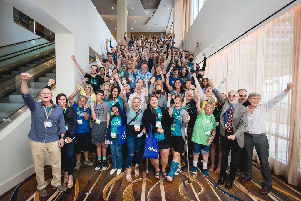 A large group raises hands in excitement at the NF Summit.