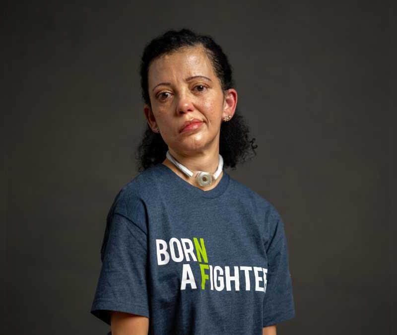 A woman wearing a t - shirt that says born a fighter.