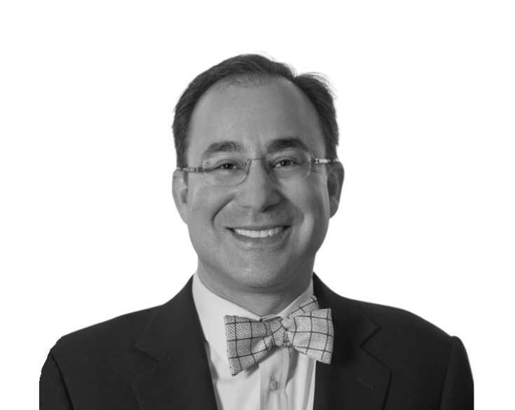 A black and white photo of a man in a suit and bow tie.