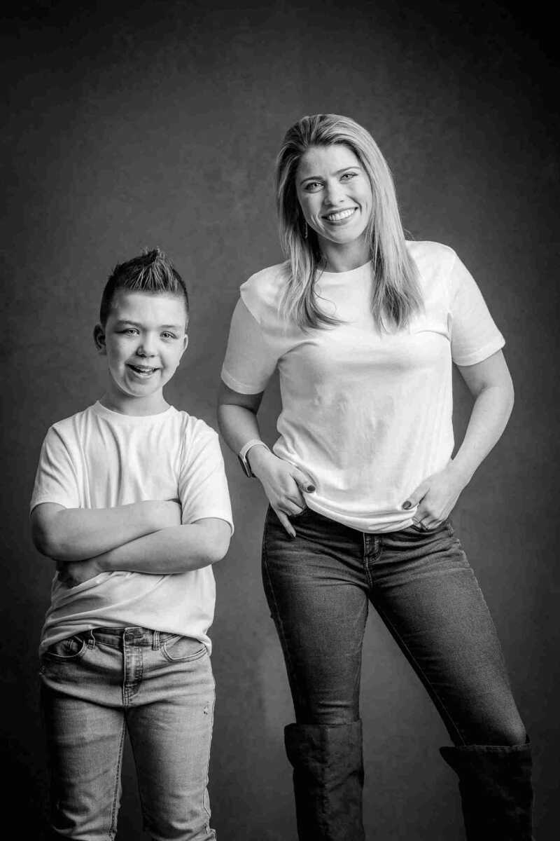 A mother and son posing for a black and white photo.