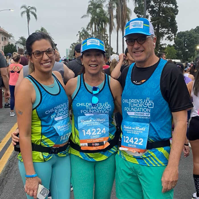 Three people posing for a photo at a marathon.