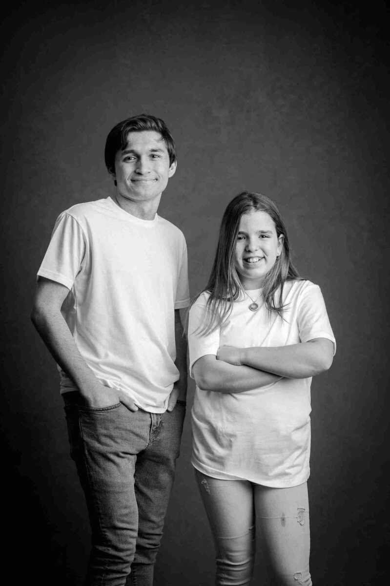 A black and white photo of a boy and girl posing for a photo.