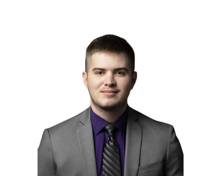 A man in a gray suit and purple tie.