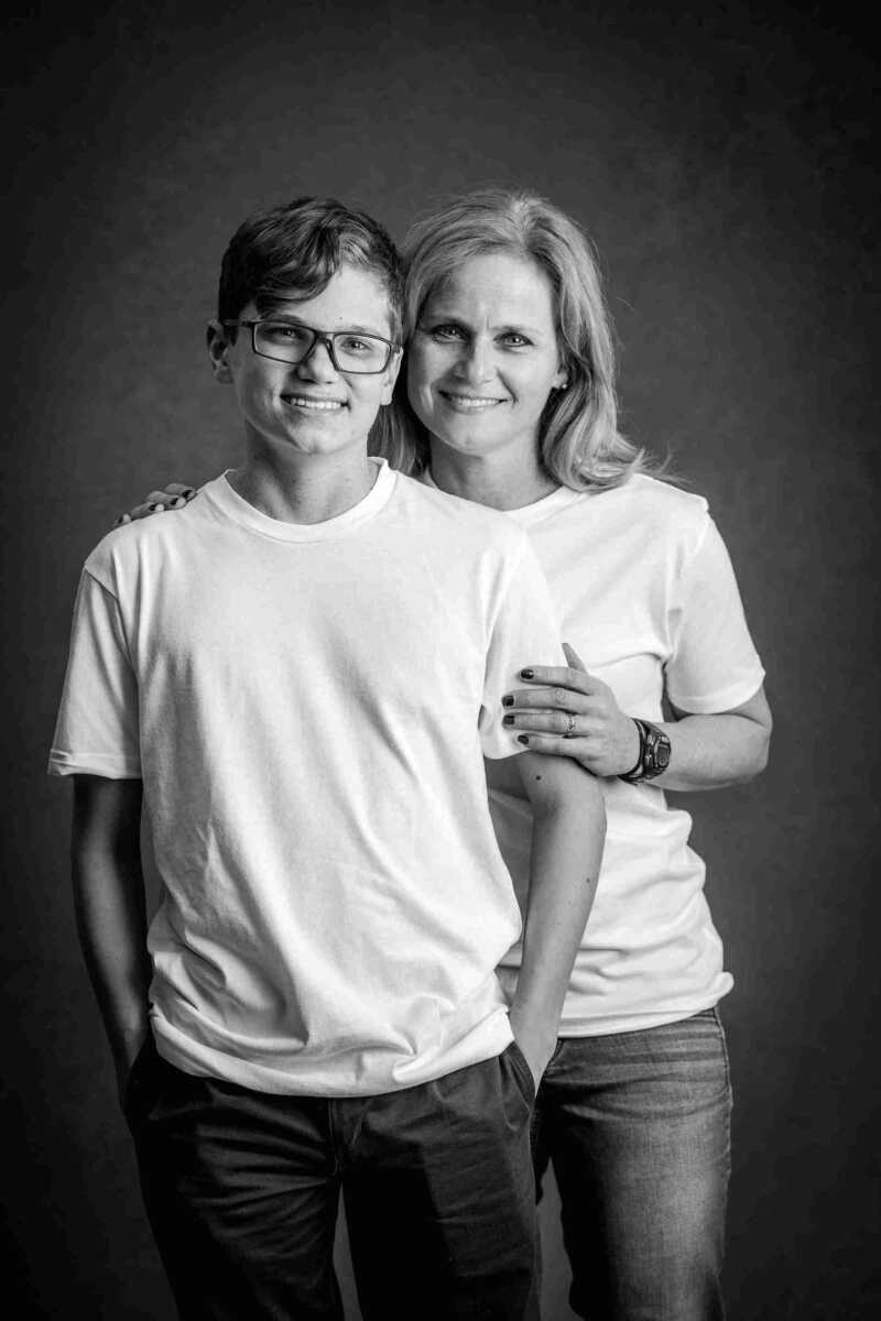 A mother and son posing for a black and white photo.