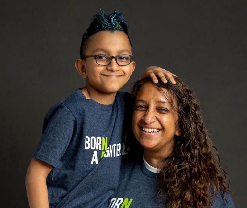 A woman and a child posing for a photo in a t - shirt.