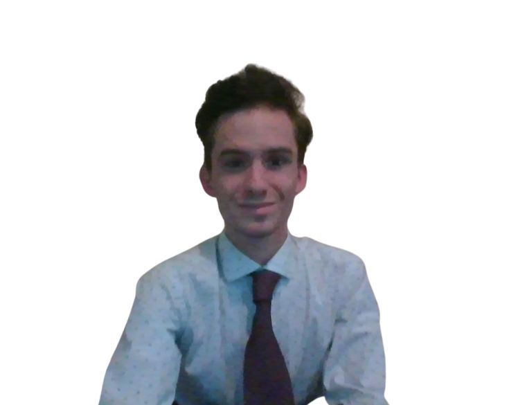 A young man in a dress shirt and tie smiling against a plain, faintly textured background.