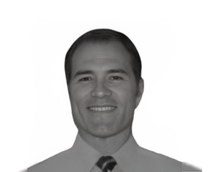 A grayscale image of a smiling man wearing a shirt and tie.