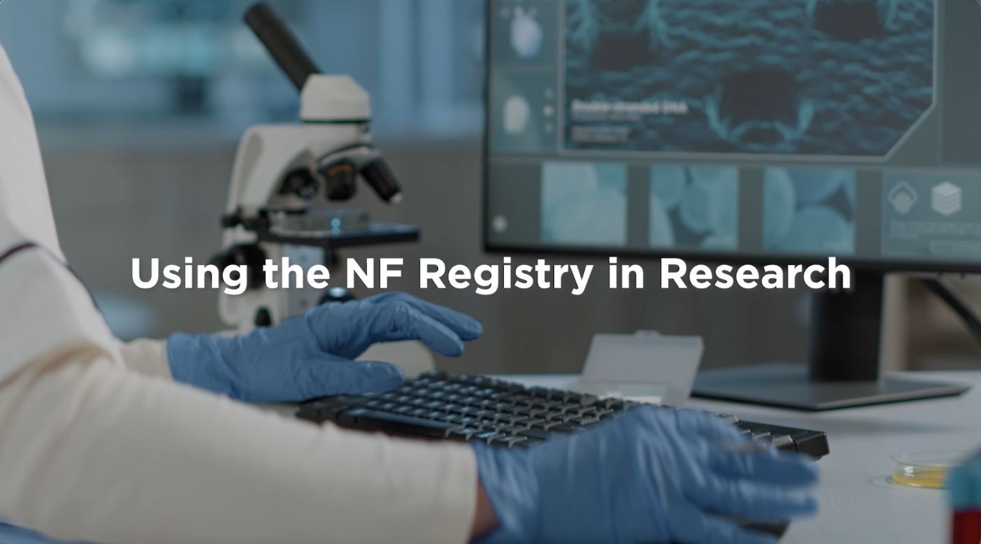 A researcher typing on a keyboard in a lab with a microscope and computer screens displaying cell images, titled "using the nf registry in research.