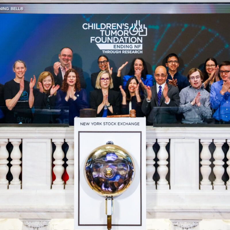 Group of people celebrating at the New York Stock Exchange for the Children's Tumor Foundation event.