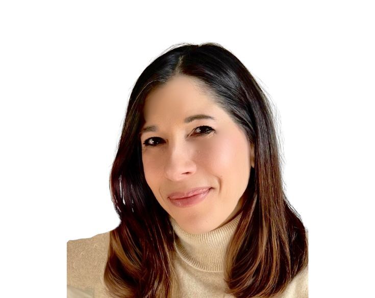A woman with straight, shoulder-length brown hair wearing a light beige turtleneck sweater, smiling slightly, against a white background.